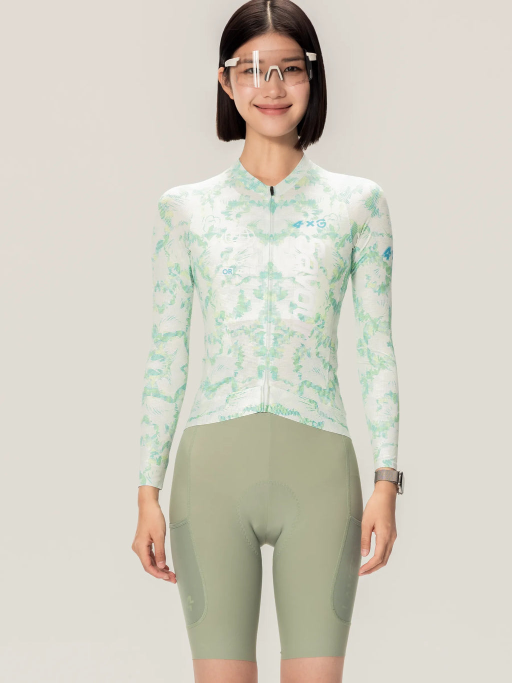 A woman wears a lameda x australian unisex cycling jersey ls in savour lime green with camouflage and blue accents