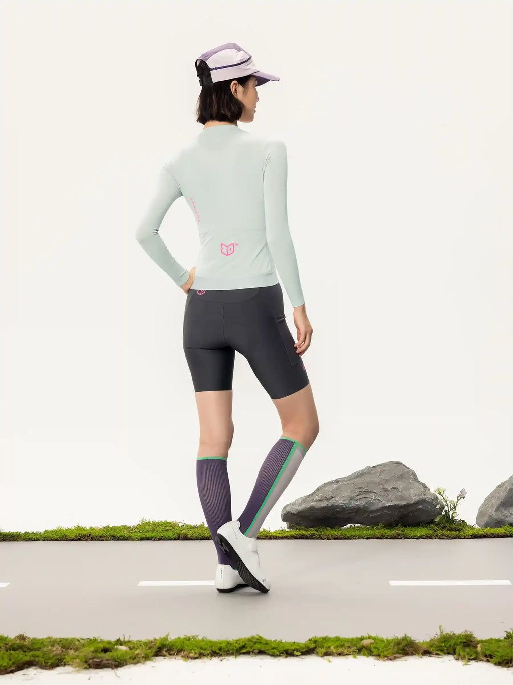 Light gray Roam women long-sleeved cycling jersey back view with light green fabric and subtle pink logo on the back