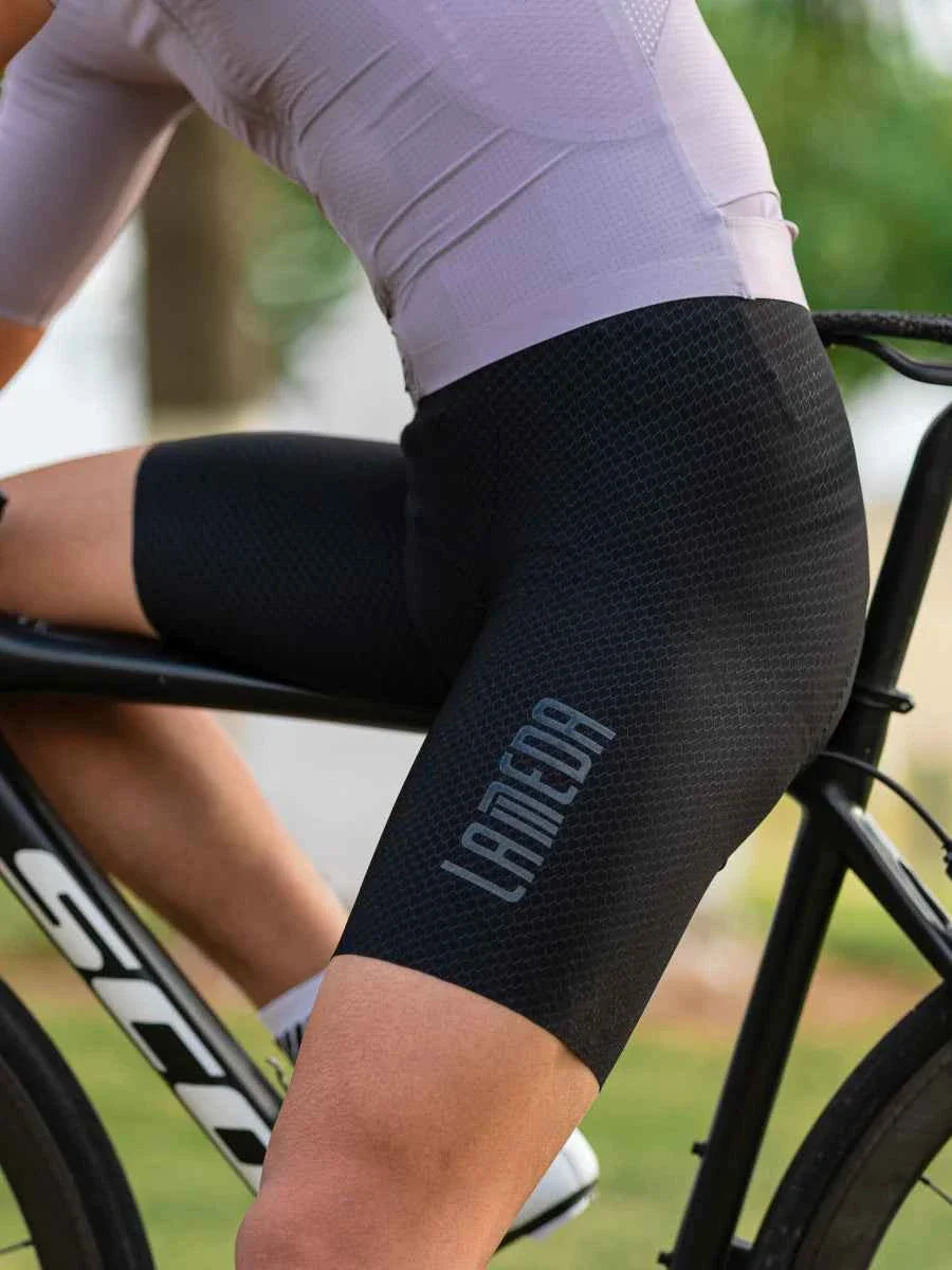 Kylin men’s bib shorts in black with breathable textured fabric, elastic interface chamois, and subtle gray logo on thigh