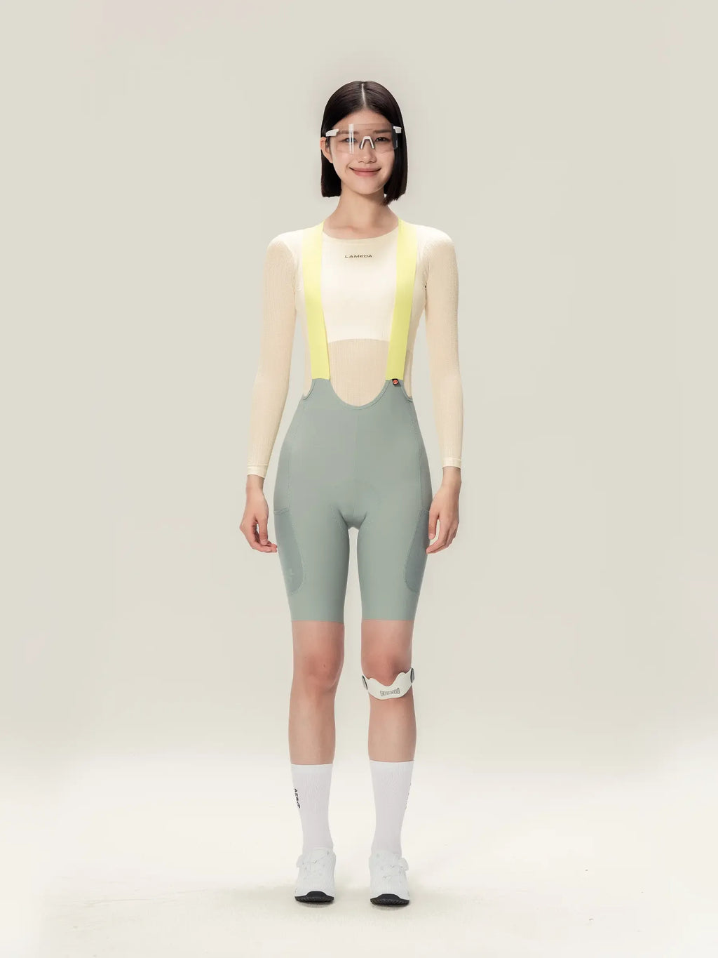 Lightweave women base layer long sleeve cream worn with sleek light gray cycling bib short and neon yellow suspenders featuring airflow mesh