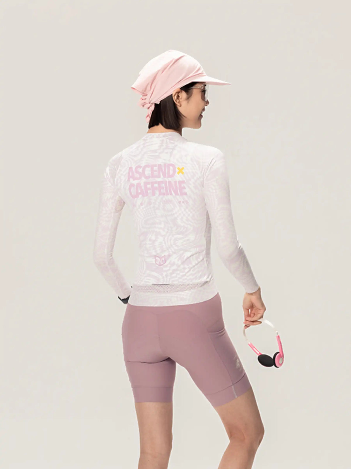 White long-sleeved unisex cycling jersey with pink ascend caffeine text and mauve shorts from lameda x australian studio