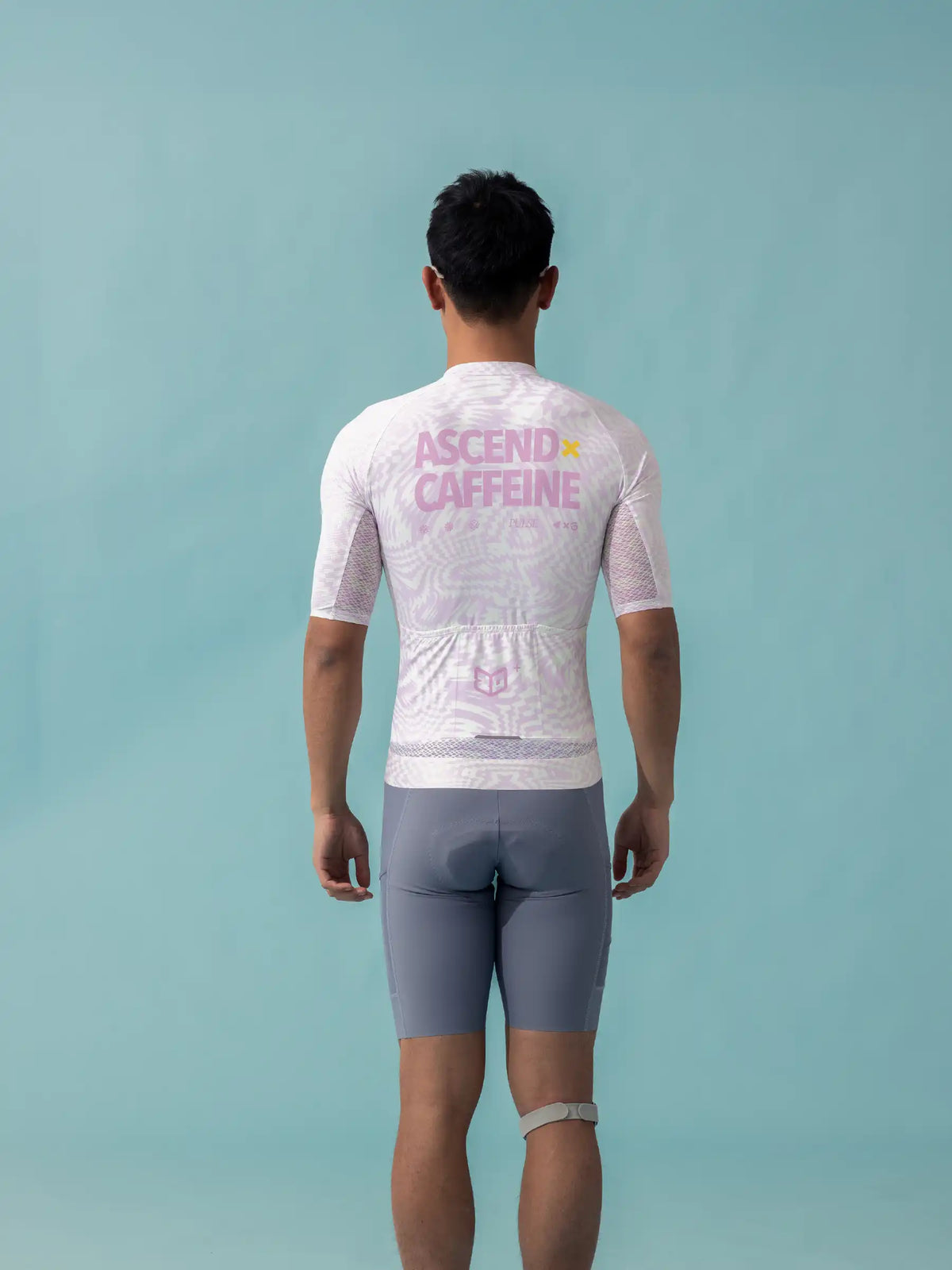 White short-sleeved lameda x australian studio unisex cycling jersey with pink ascend caffeine text and mesh sleeves