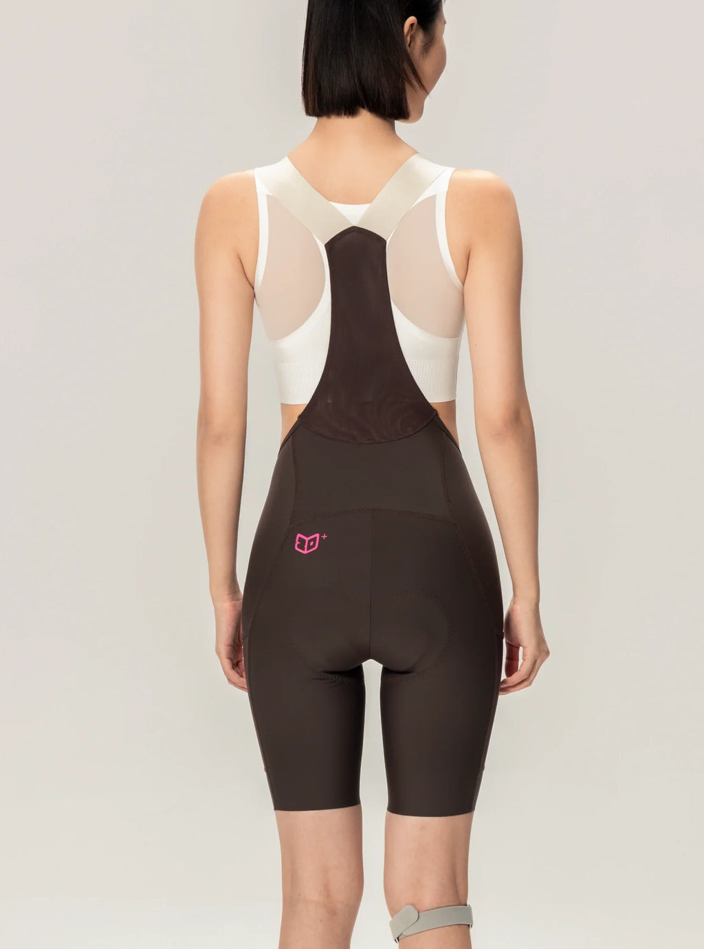 Brown lameda 21st anniv special womens cycling bib shorts with white mesh back panel and pink logo on lower left hip elastic interface