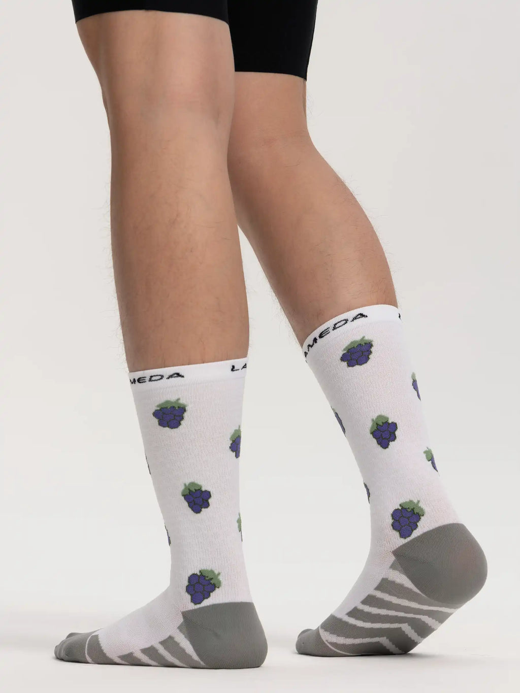 Lameda cycling socks made of fruits grape feature white fabric with purple grape pattern and gray reinforced arch support