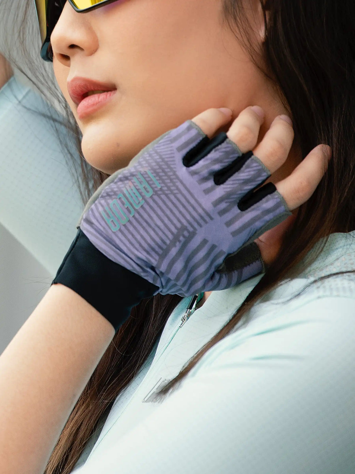 Back side of purple and black half-finger cycling gloves with geometric pattern delivering essential protection