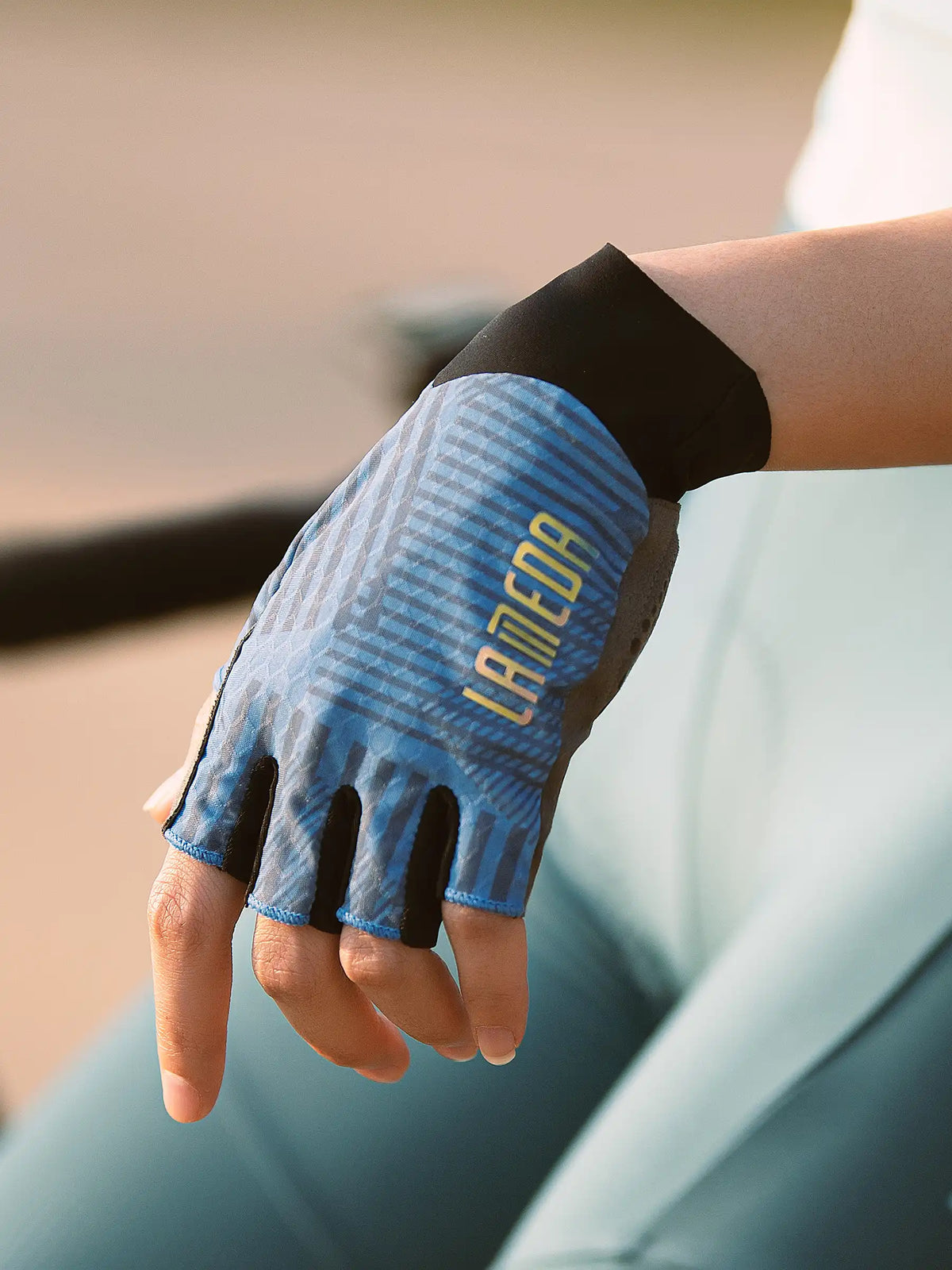 Blue and black half-finger cycling gloves with textured pattern and lameda branding deliver essential protection