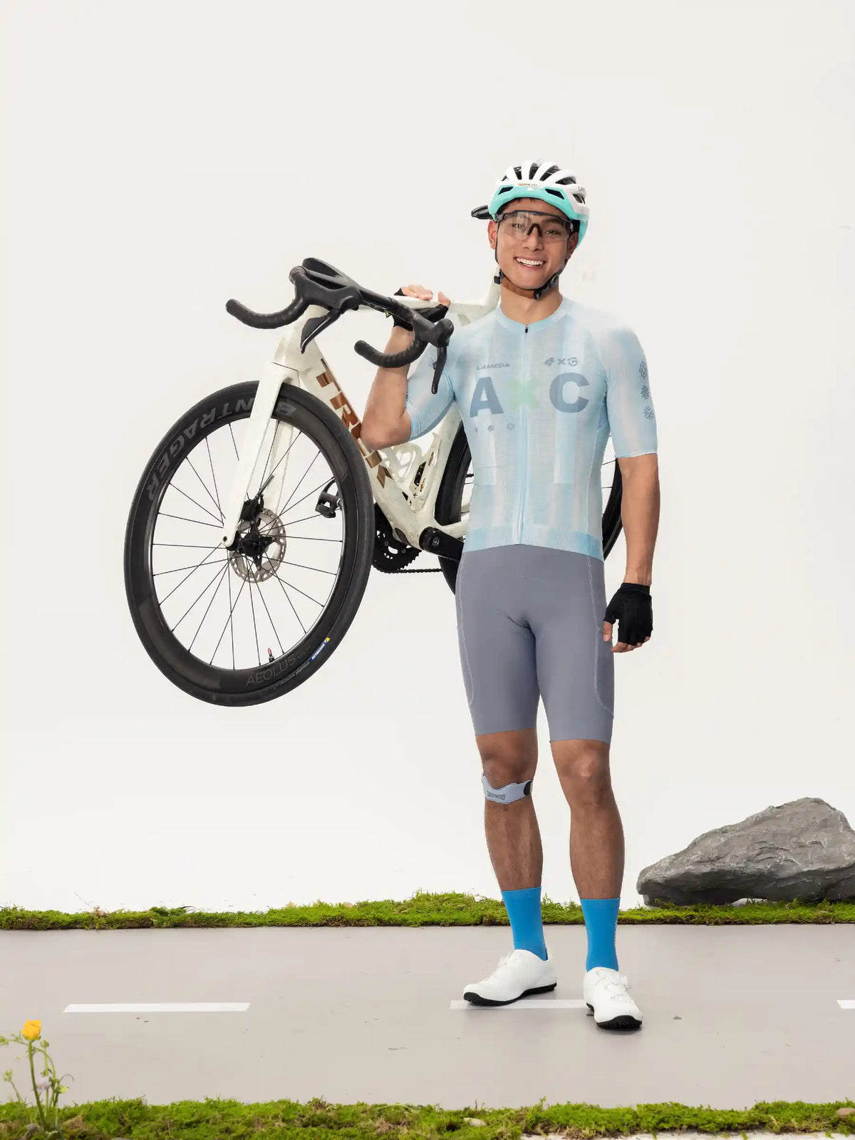 Light blue and white lameda x australian studio unisex cycling jersey with black handlebars and tires road bike