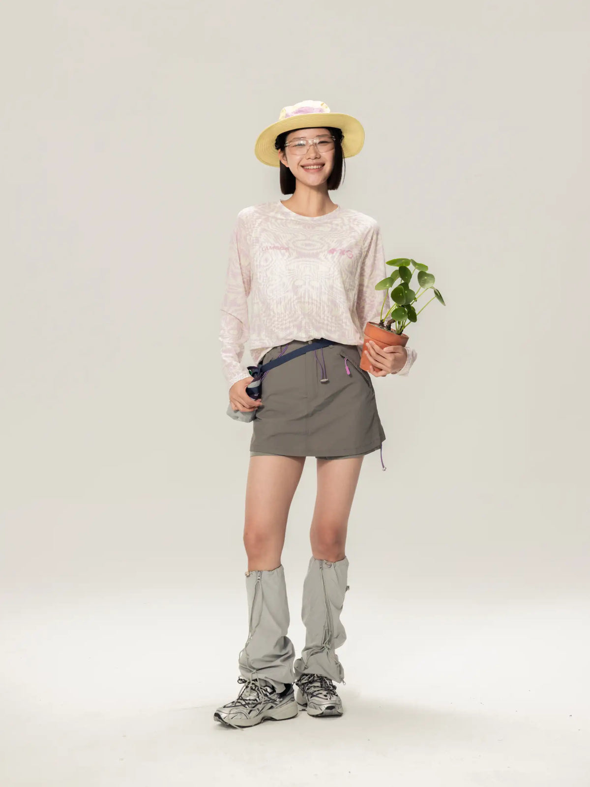 A terracotta pot with a small green plant beside a light pink a x c unisex lightweight cycling long-sleeve t-shirt for daily commutes