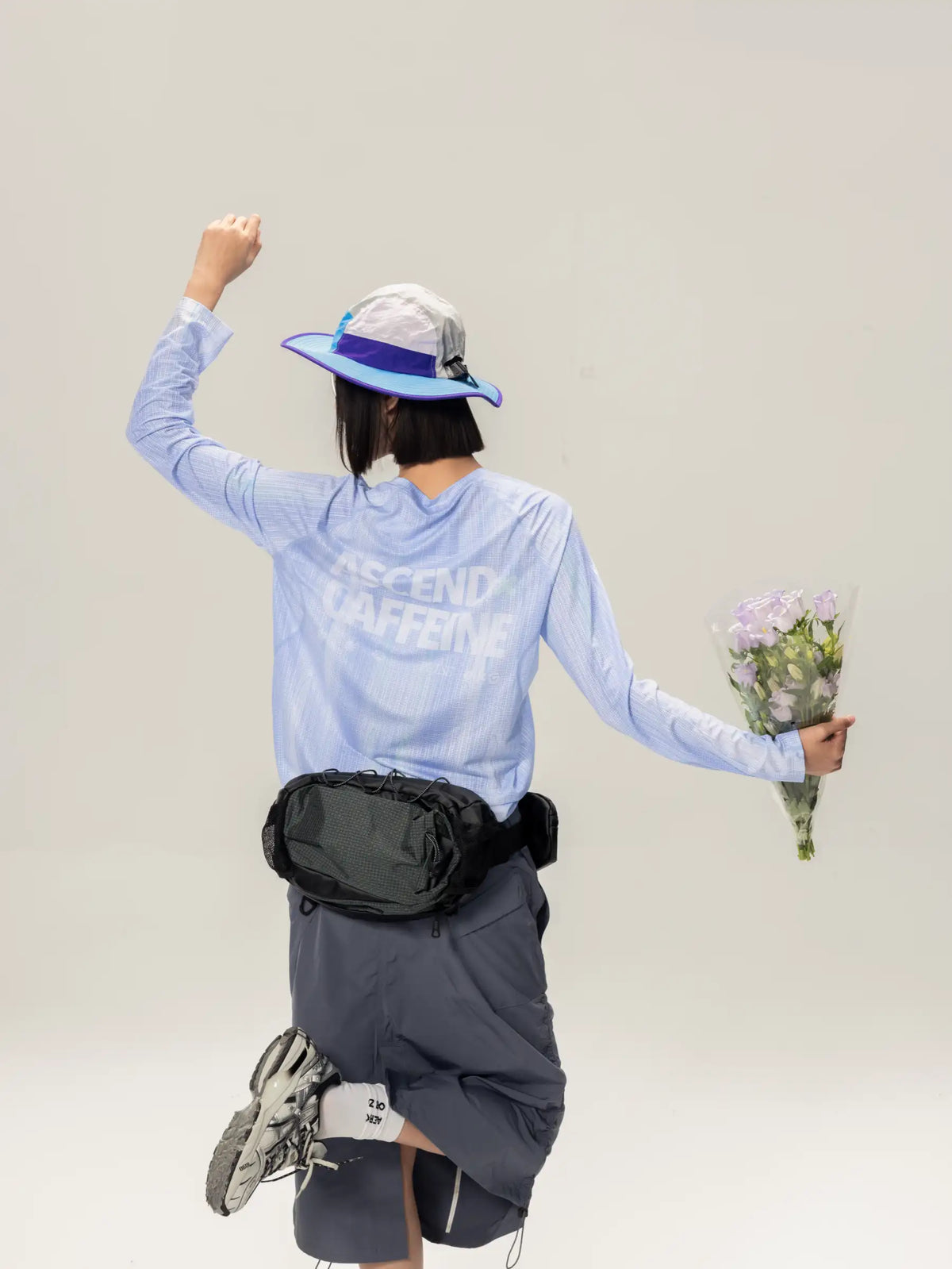 Black tactical-style waist pack with adjustable straps and zippered main compartment paired with axc unisex lightweight cycling long-sleeve t-shirt in blue featuring highly breathable fabric