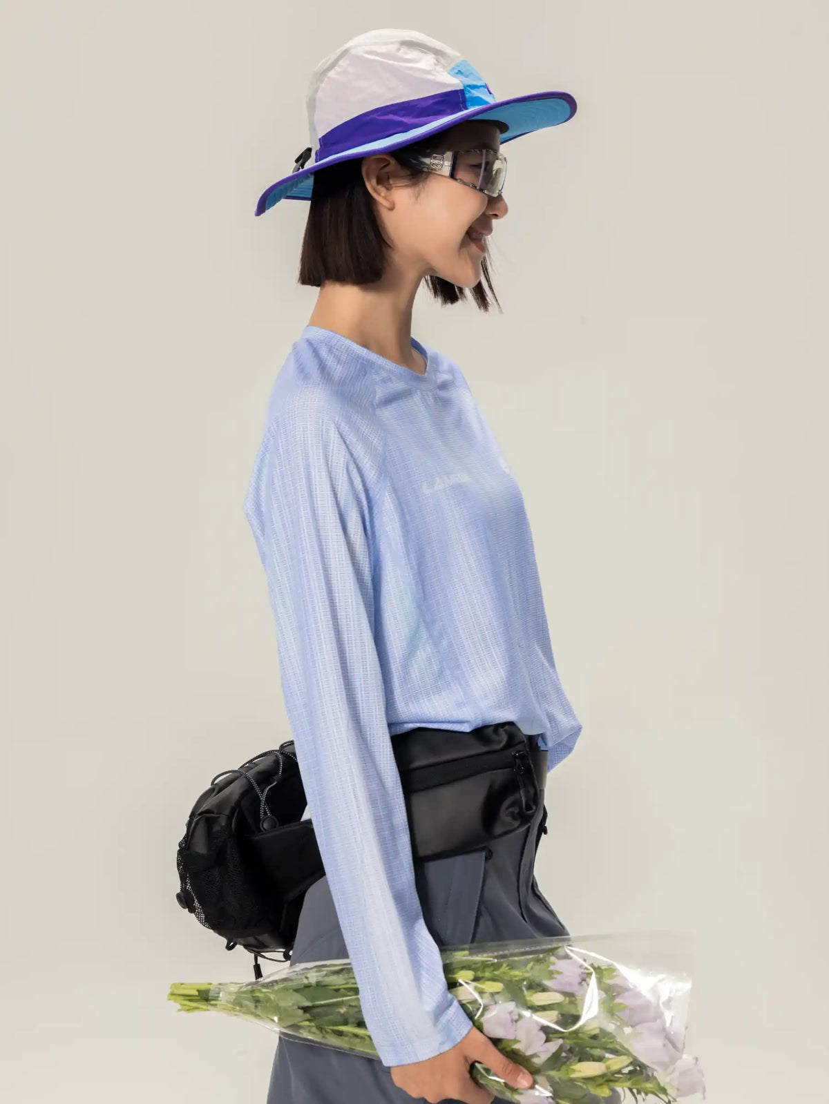 Blue and white bucket hat with translucent visor paired with a lightweight cycling long-sleeve t-shirt in blue with highly breathable fabric