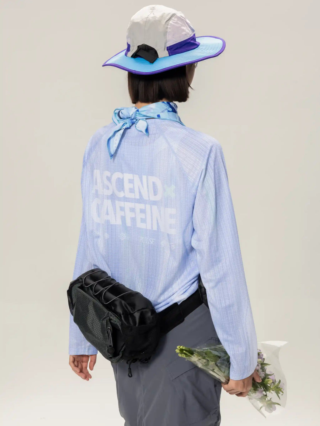 Black mesh crossbody bag with adjustable strap and front zipper pocket paired with blue lightweight cycling long-sleeve t-shirt in highly breathable fabric