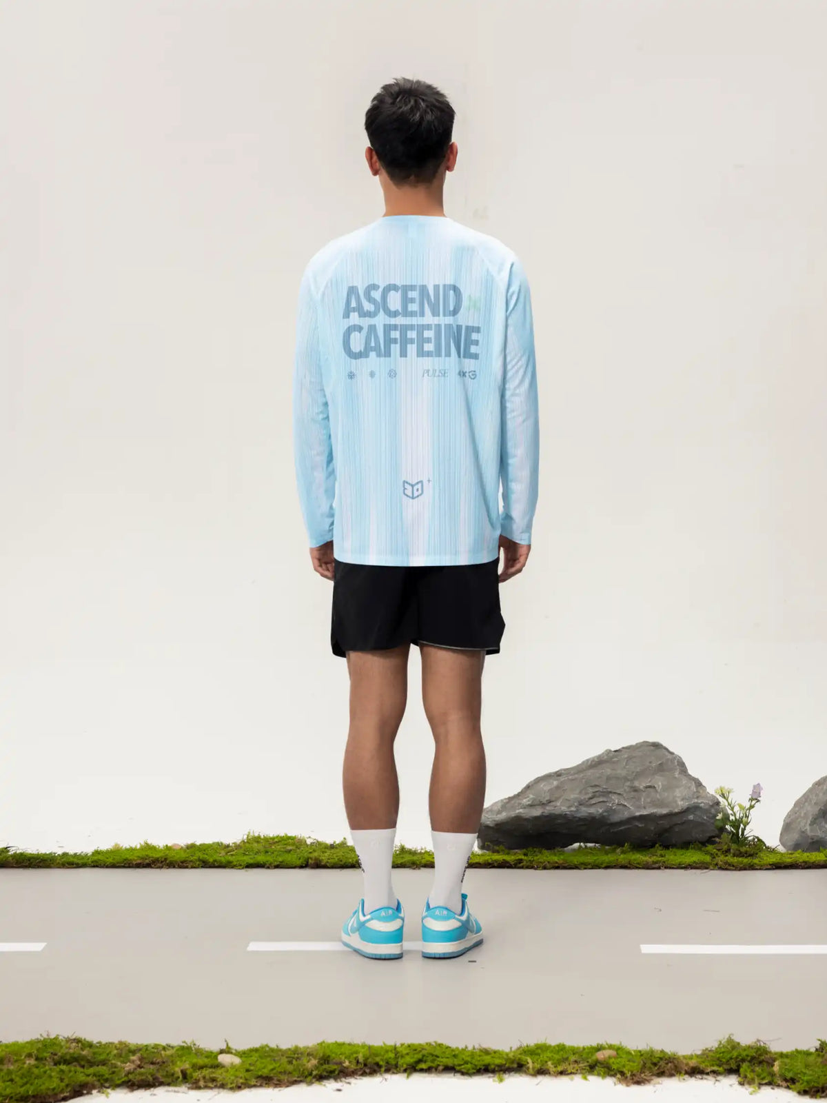Back view of light blue lightweight cycling long-sleeve t-shirt with ascend caffeine print for outdoor adventures