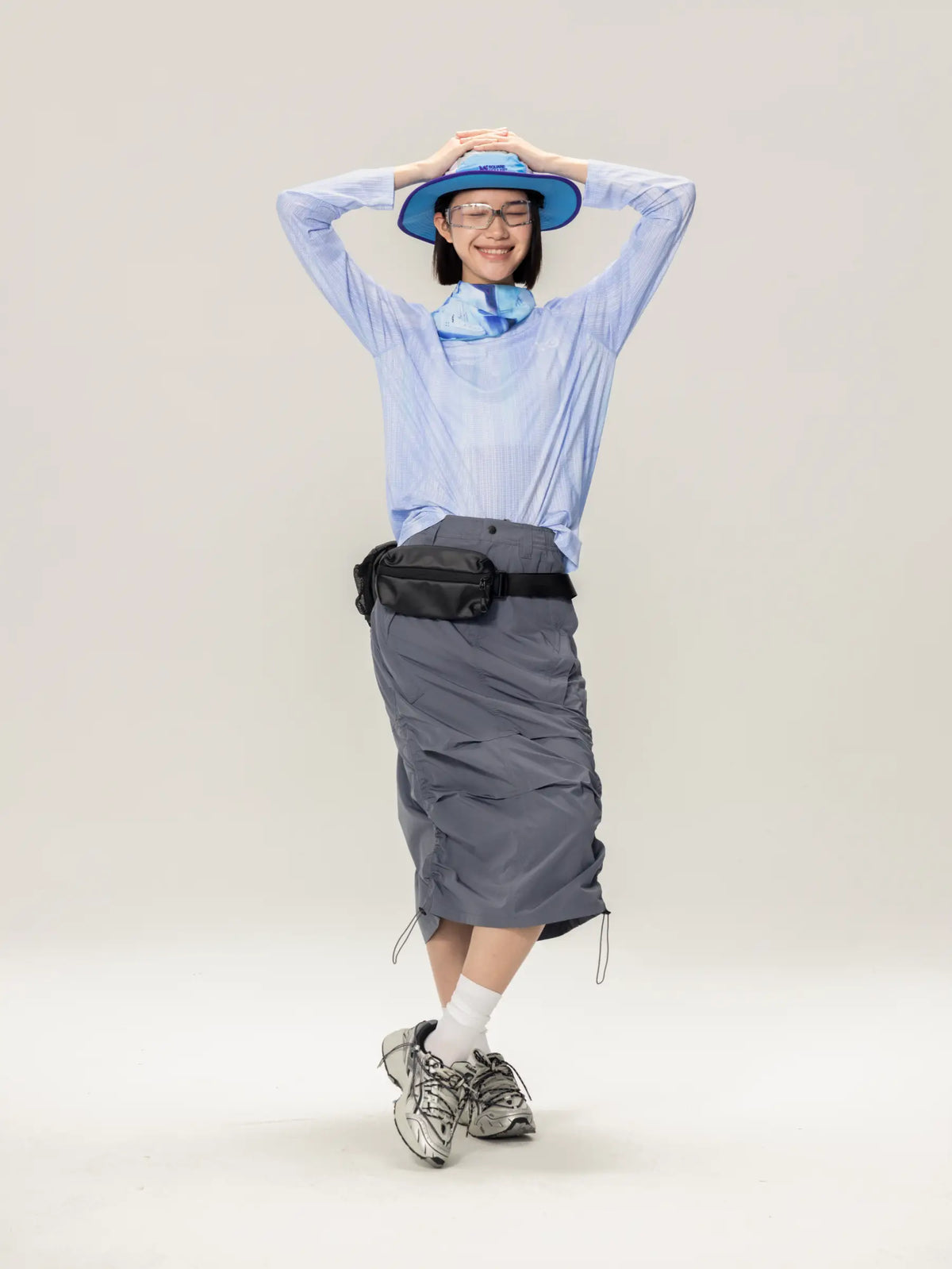 Gray utility belt with black adjustable strap and side pockets worn with a blue a x c unisex lightweight cycling long-sleeve t-shirt made of highly breathable fabric
