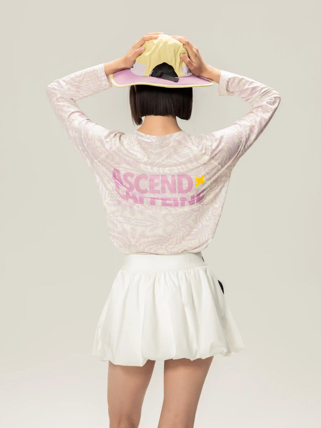 A person wearing the back of a white lightweight cycling long-sleeve t-shirt with ascend print, ideal for daily commutes