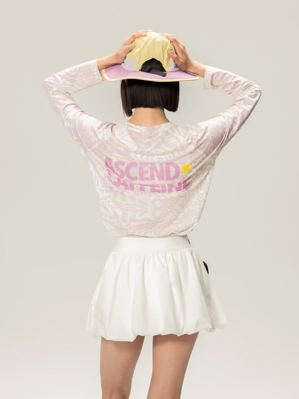 A person wearing the back of a white lightweight cycling long-sleeve t-shirt with ascend print, ideal for daily commutes