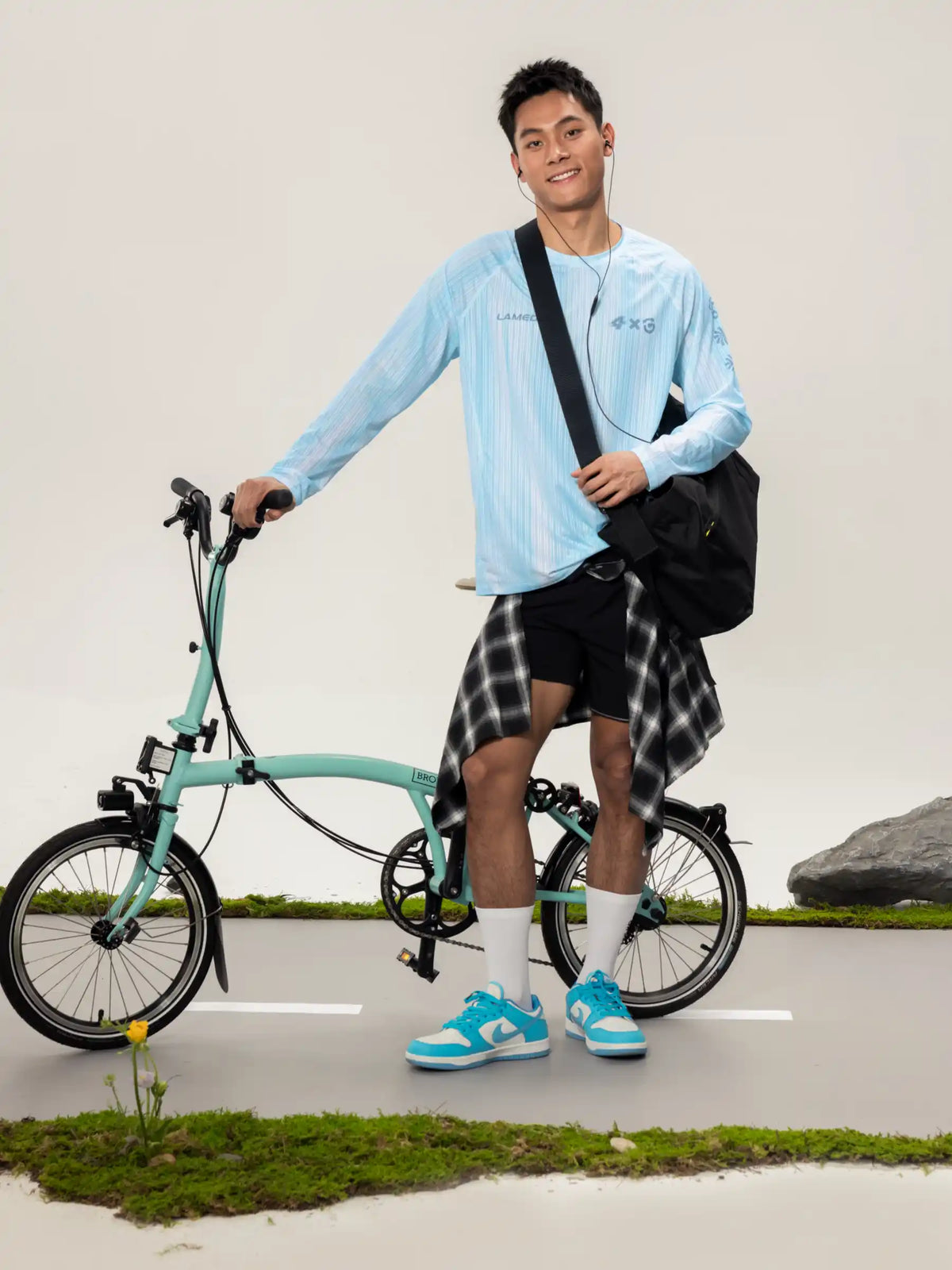 Mint green brompton folding bicycle paired with A x C unisex lightweight cycling long-sleeve t-shirt for outdoor adventures