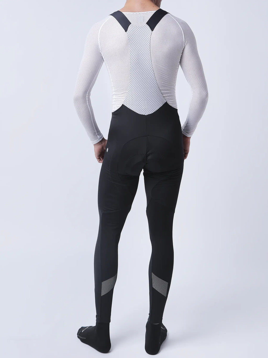 Men’s black cycling bib tights with fleece-lined thighs and reflective calf panels paired with white mesh long-sleeve top