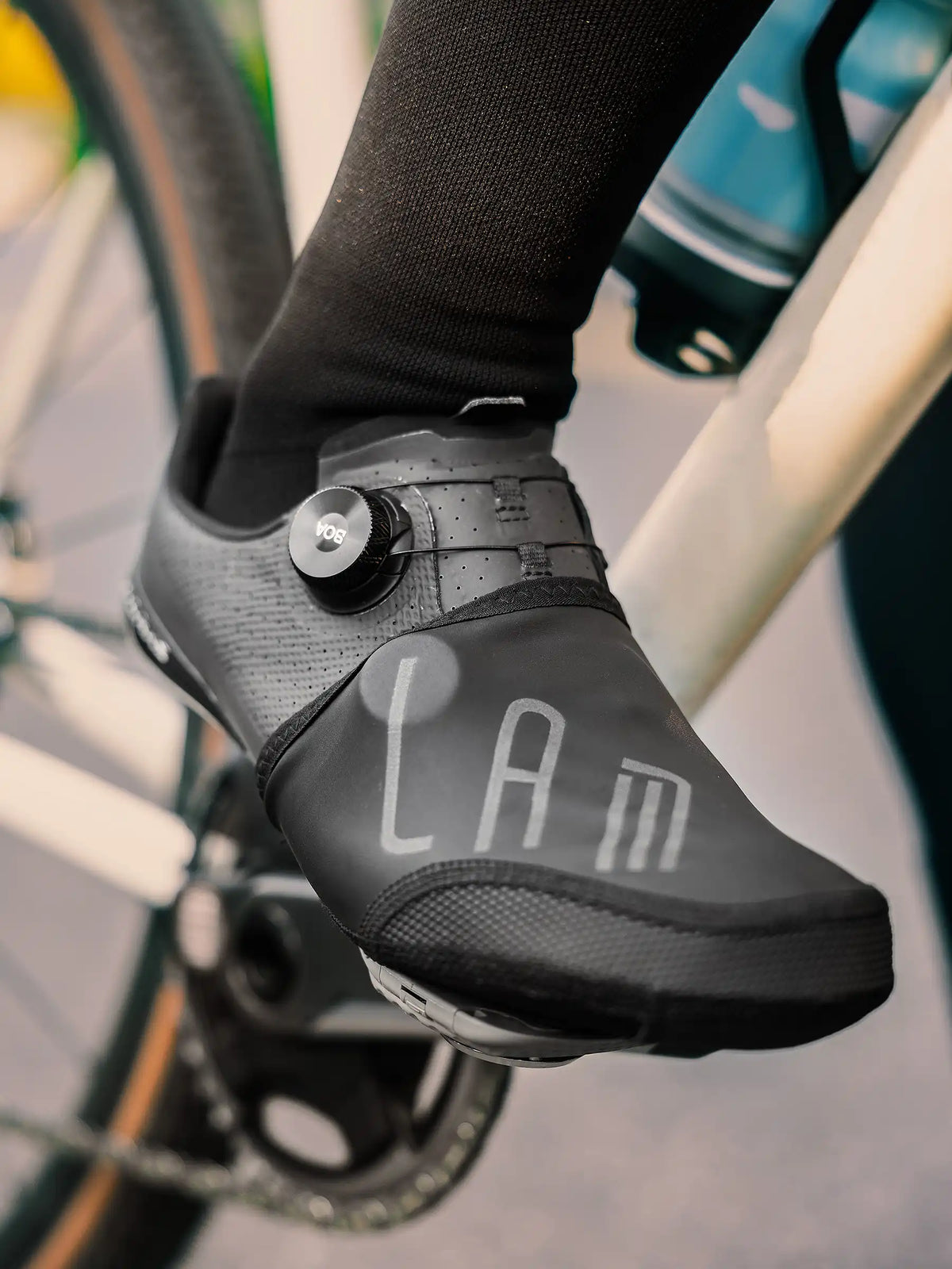 Black lam cycling shoe with aerodynamic design and perforated upper featuring windproof cycling shoe toe covers