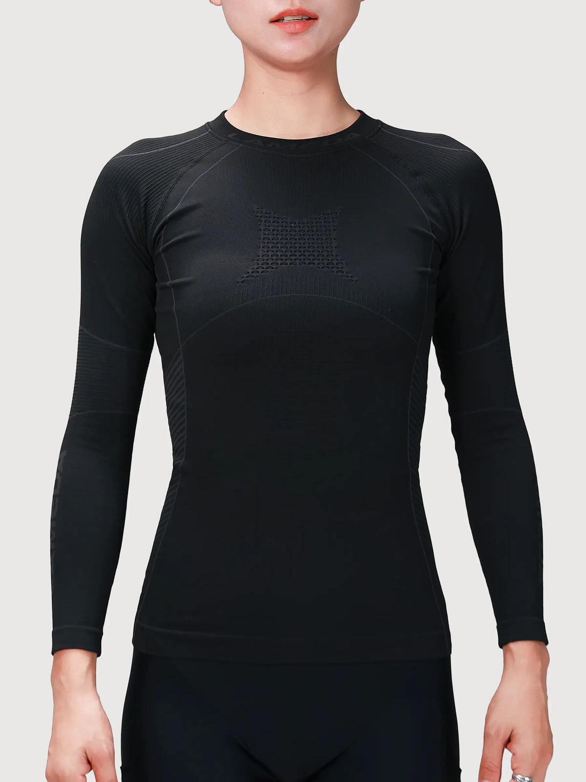 Women’s compression top in black featuring bamboo charcoal fiber with textured paneling for cycling compression and muscle support