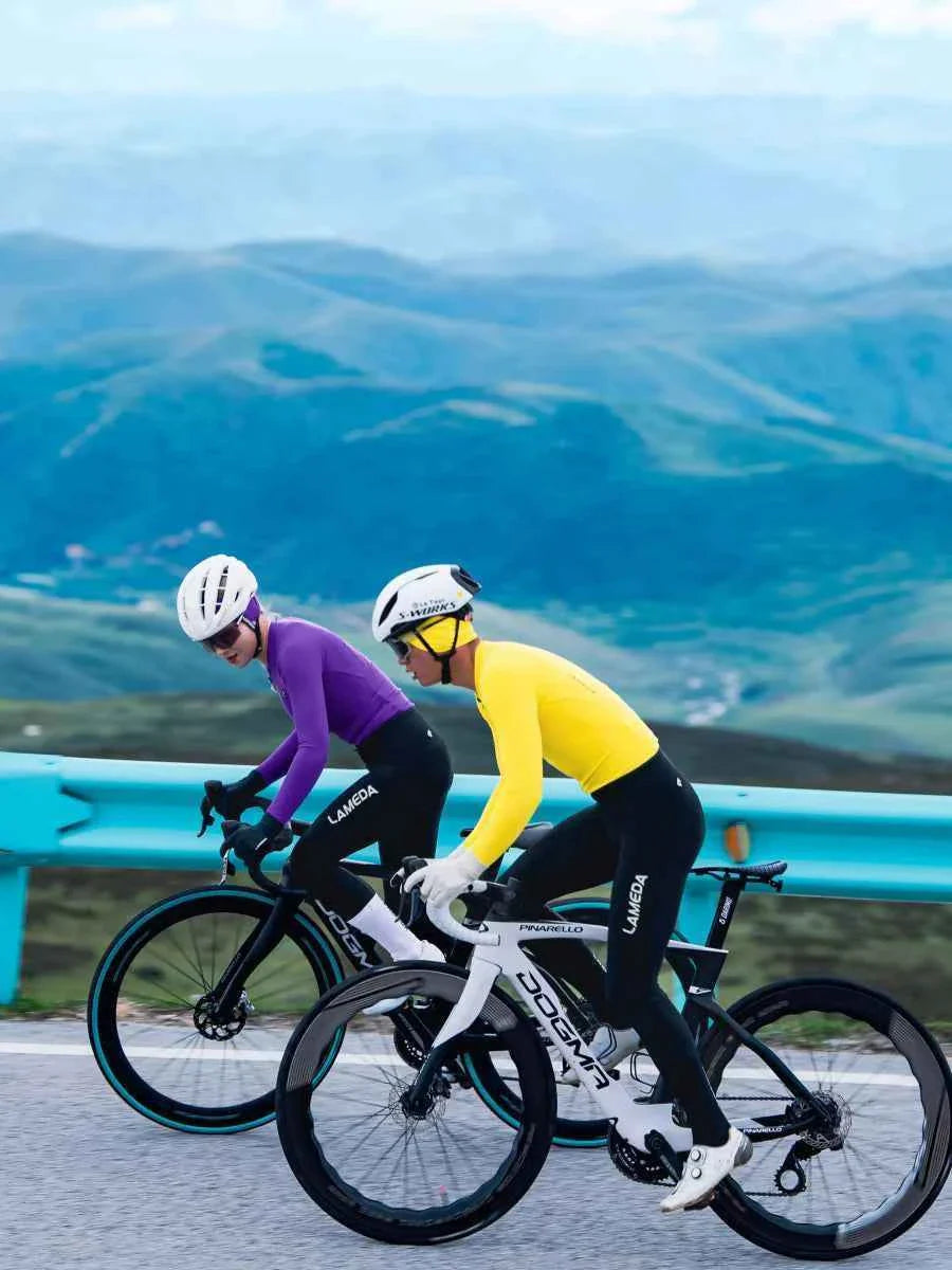 White and black pinarello bicycle with sleek aerodynamic frame alongside purple polar night mens fleeced thermal jersey