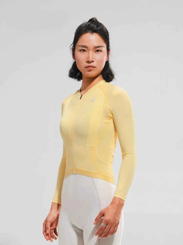 A pale yellow lameda women’s cycling long-sleeved jersey with moisture-wicking fabric and anti-slip hem