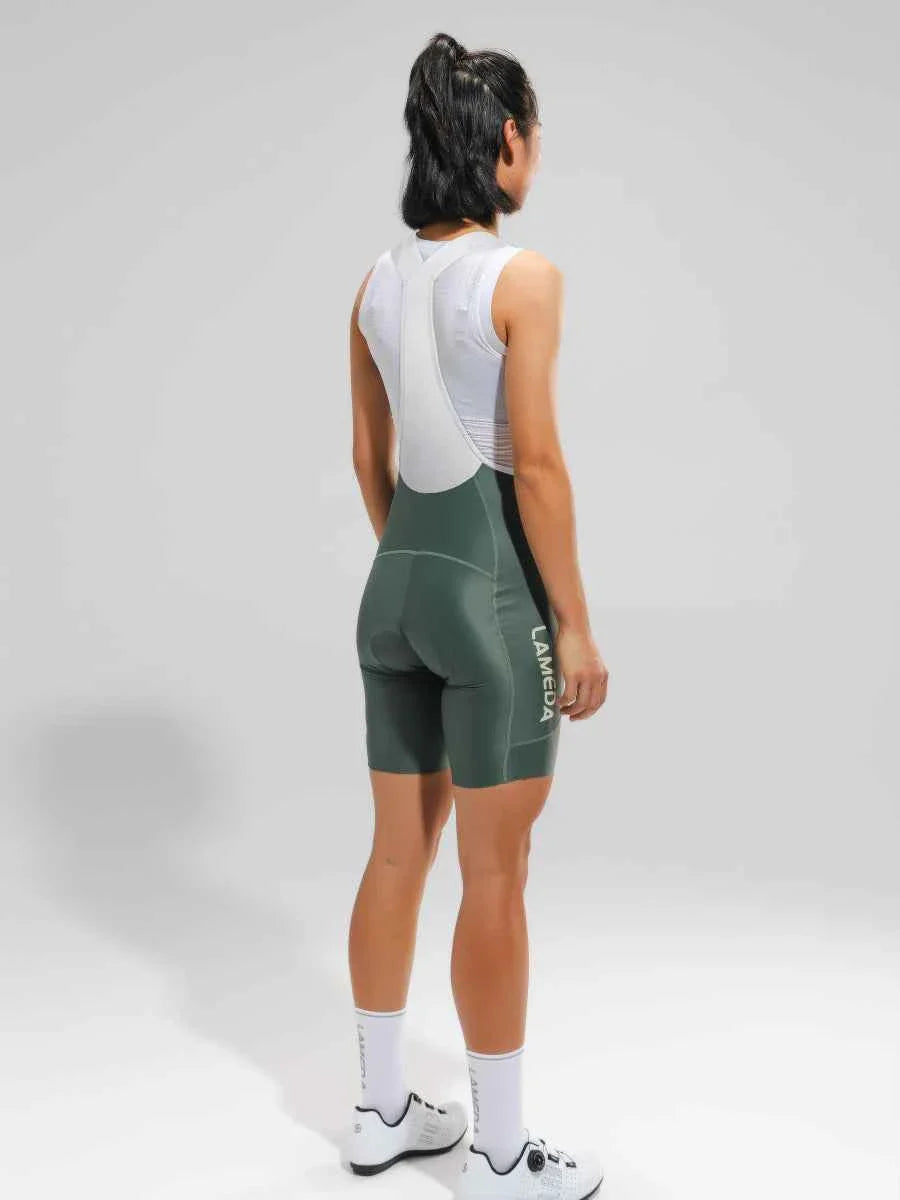 Women’s elite bib shorts in olive green and white with breathable mesh waistband and anti-slip leg grippers by lameda