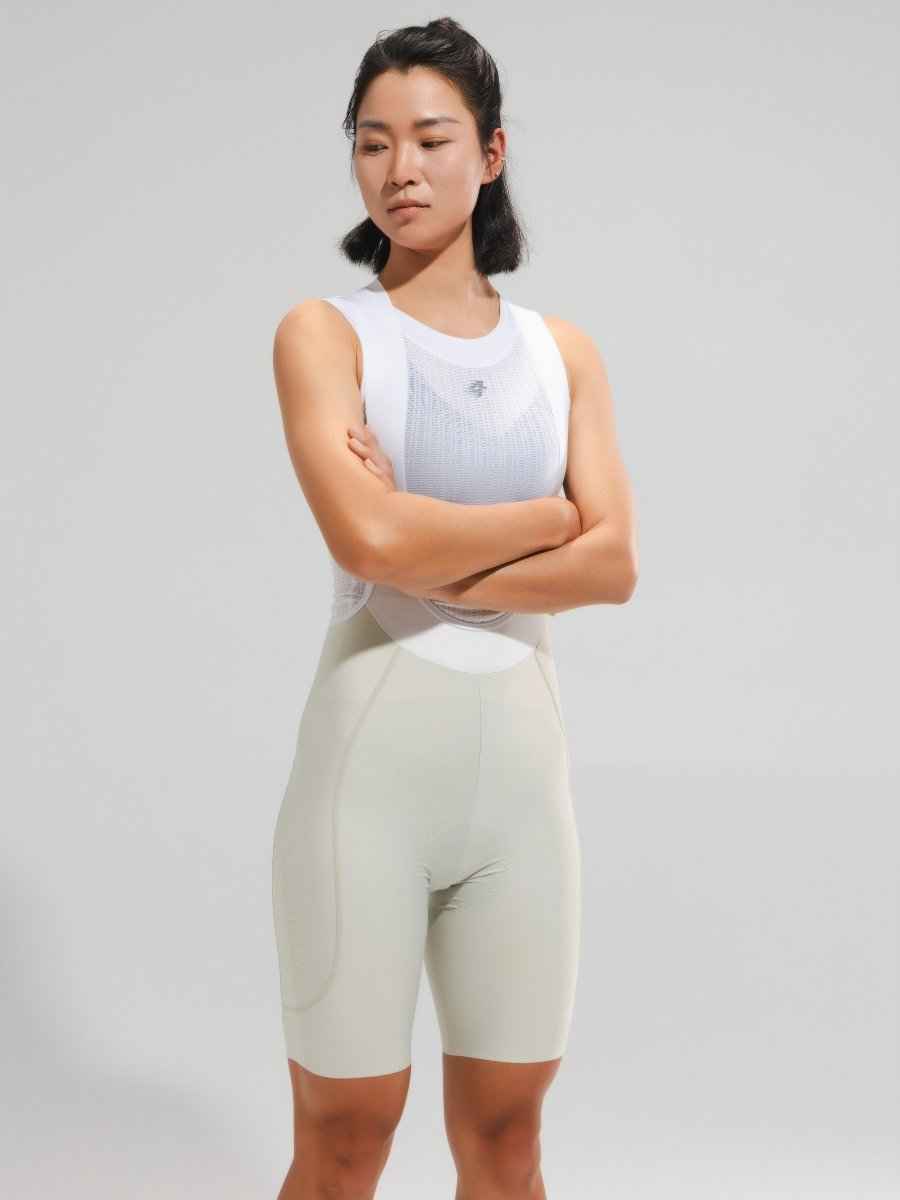 A woman wearing women’s elite bib shorts 2025SSXX488 cream with anti-slip leg grippers and breathable mesh waistband
