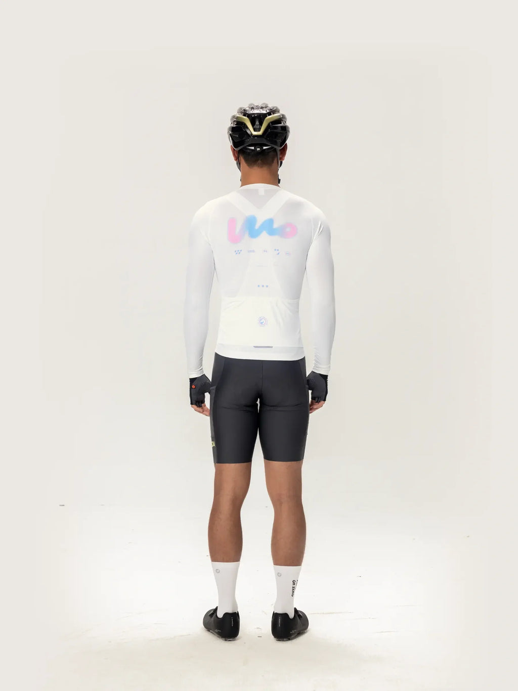 Back view of lameda women’s cycling white long-sleeved jersey with pastel pink and blue logo for women’s cycling jersey