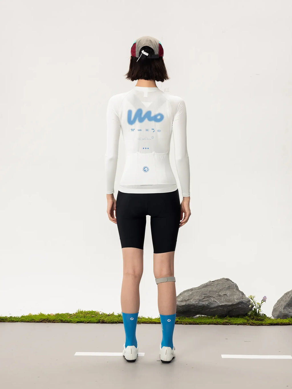 White long-sleeved lameda women’s cycling jersey with blue mo logo and subtle back graphic details for women’s cycling